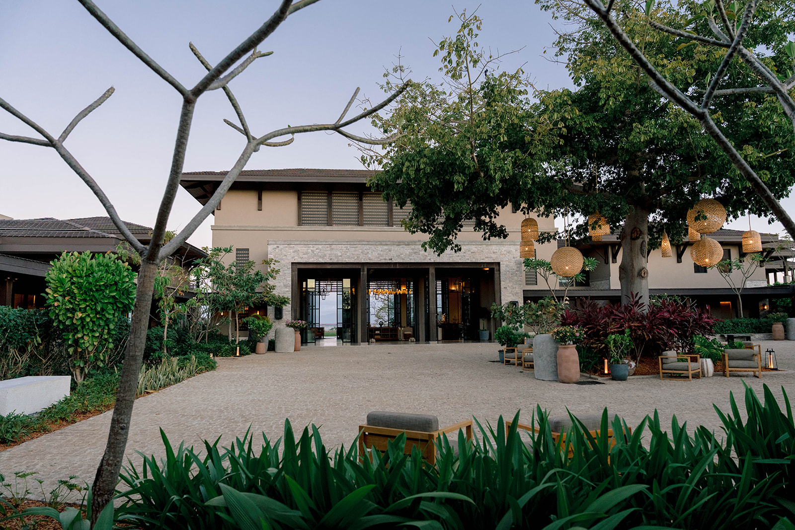 Nekajui Ritz Carlton Reserve entrance with landscaping and hanging lanterns.