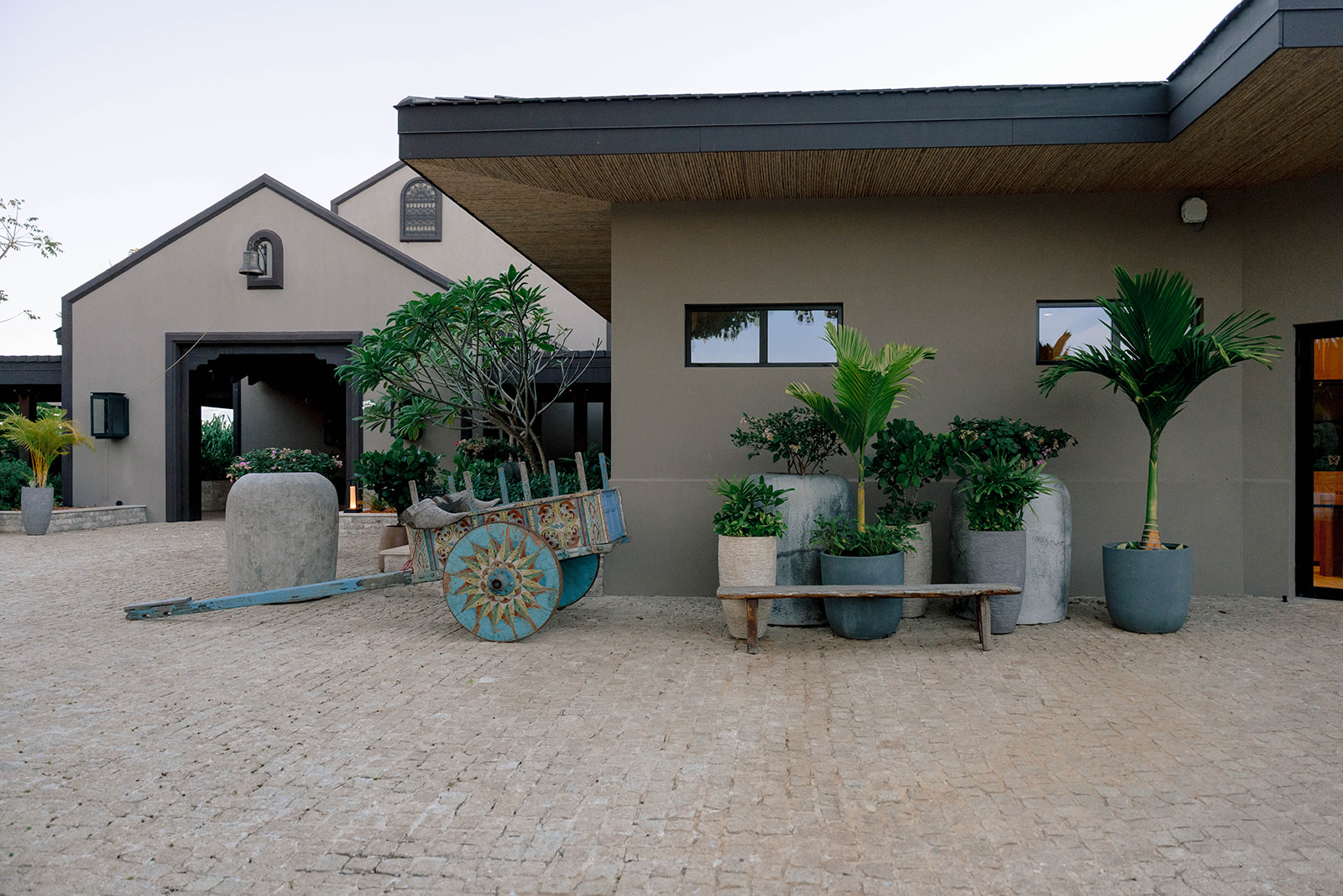 Nekajui Ritz Carlton Reserve entrance with a colorful cart and potted plants.