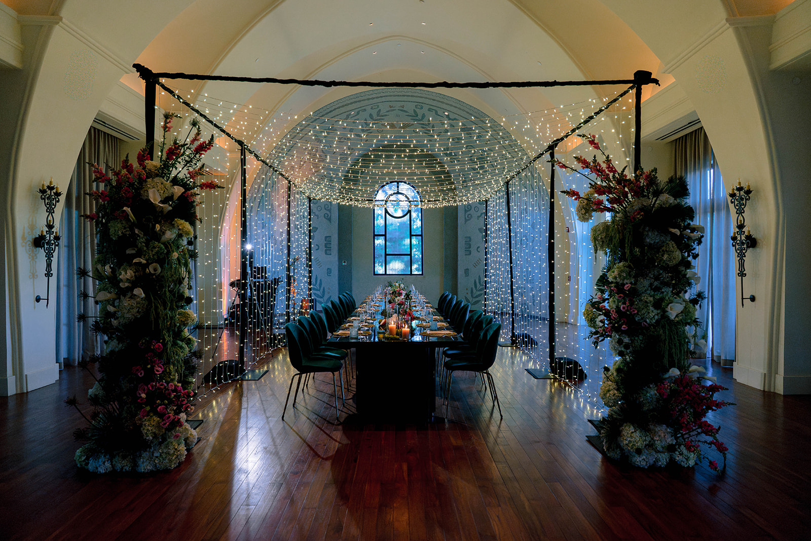 Elegant dining table at Nekajui, a Ritz Carlton Reserve, with floral decor and string lights.
