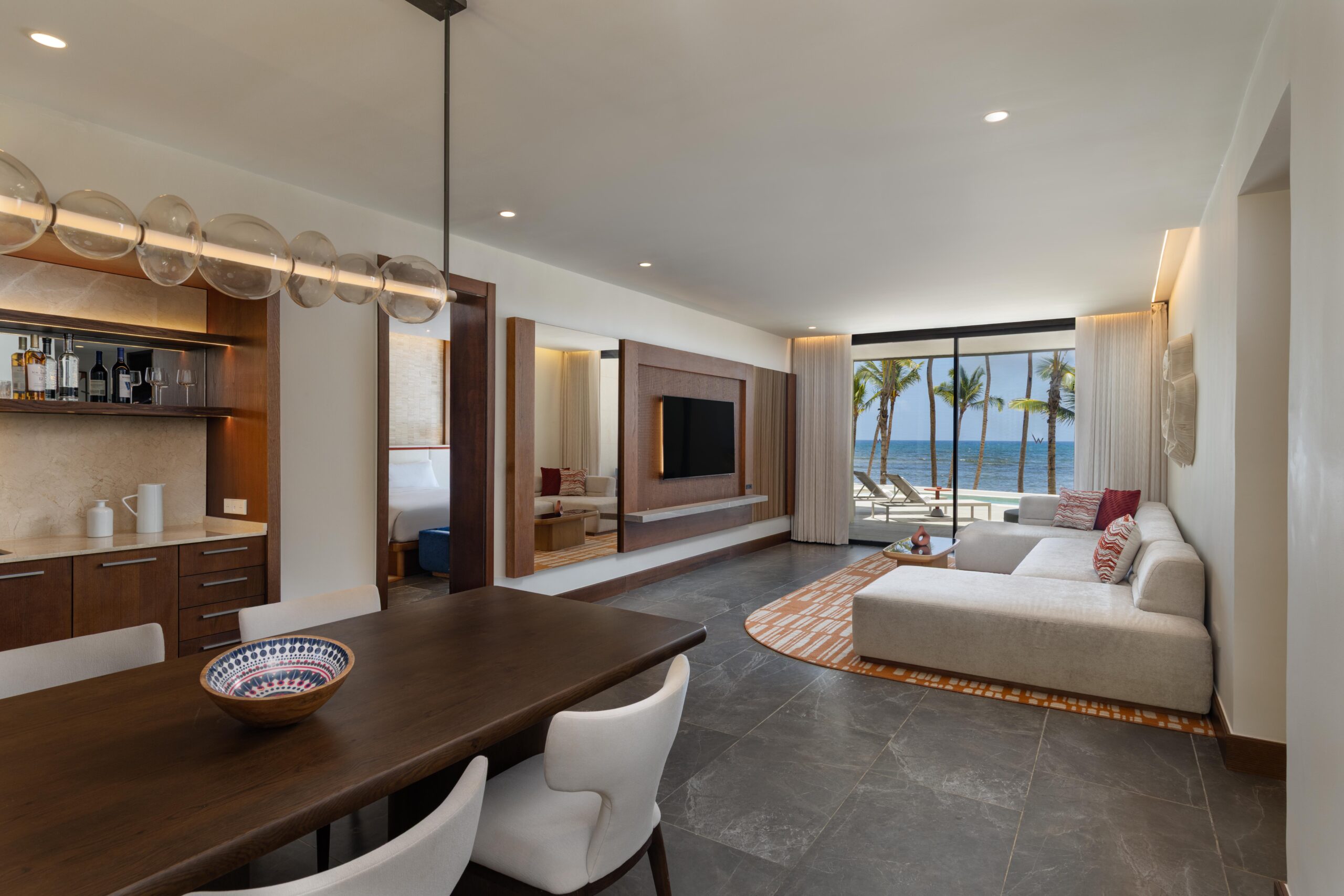 W Punta Cana suite with dining table, living area, and ocean view. Adult all-inclusive luxury.