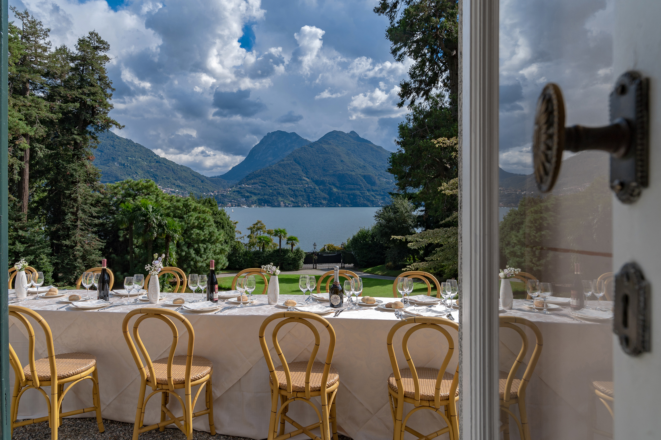 Elegant dining table at one of the private celebration villas in Italy, overlooking a lake and mountains.