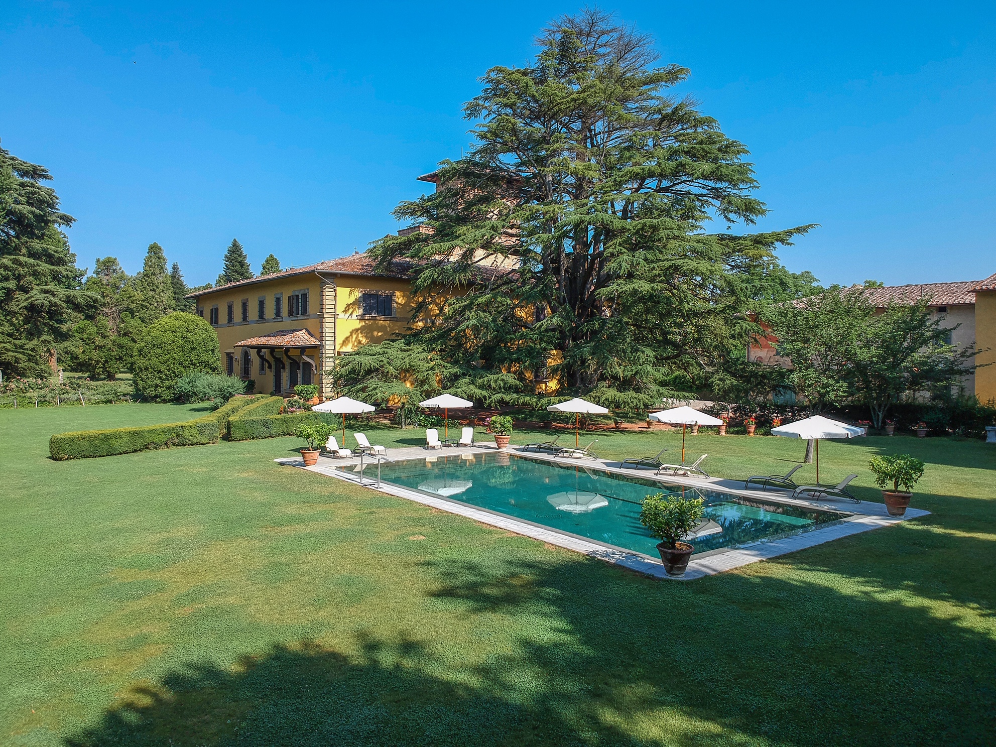 Luxury villa in Italy with pool, lawn, and parasols. One of the private celebration villas in Italy.