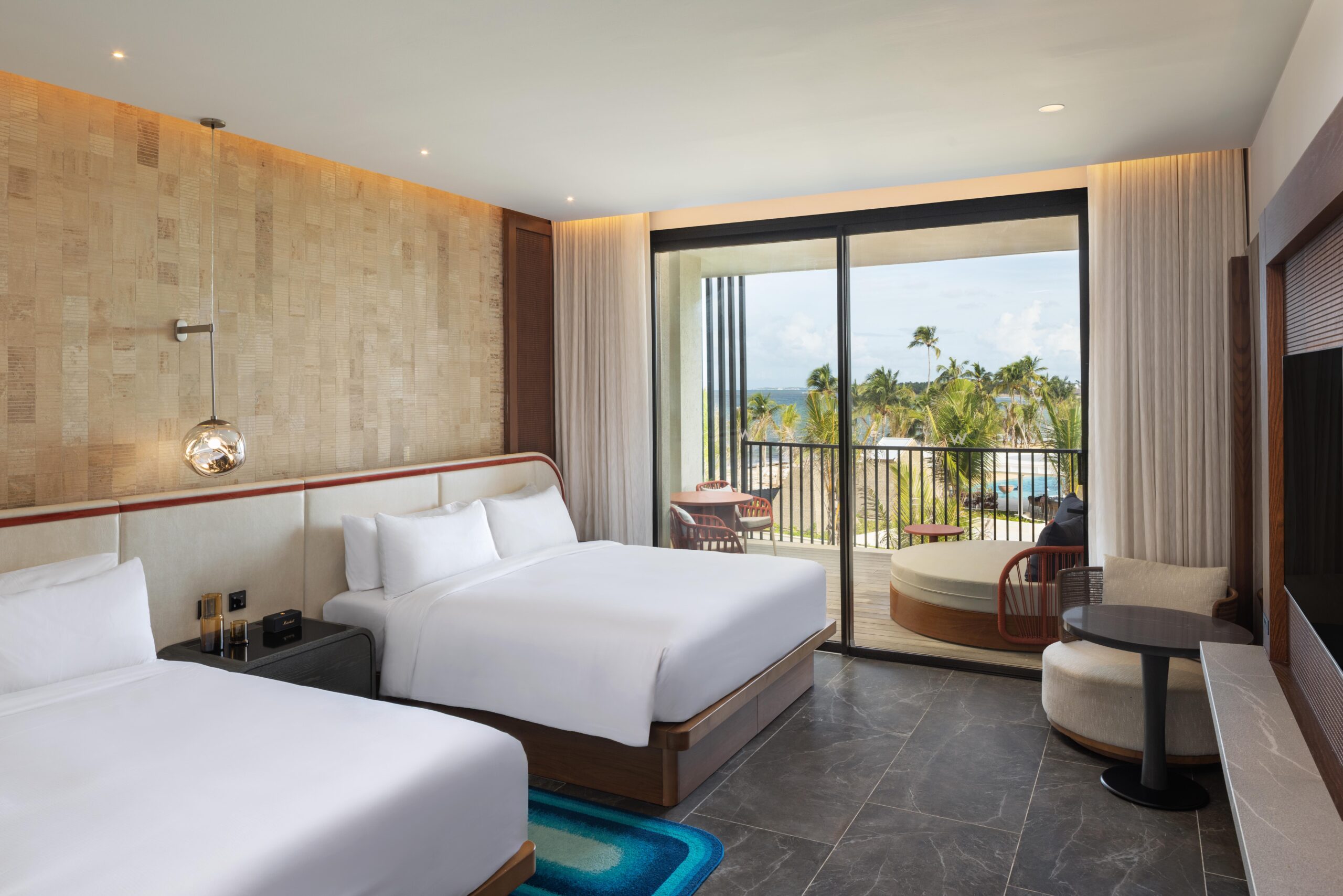 Luxurious W Punta Cana hotel room with balcony view of palm trees and pool.