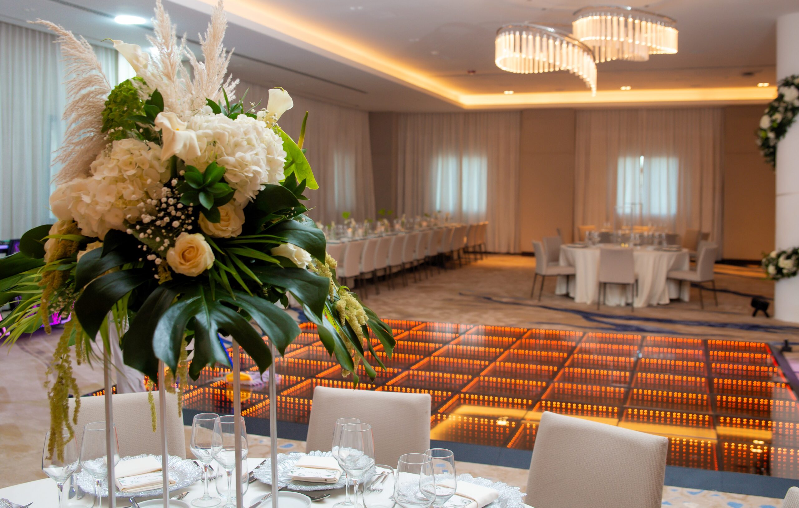 Elegant wedding reception setup with floral centerpiece and dance floor.