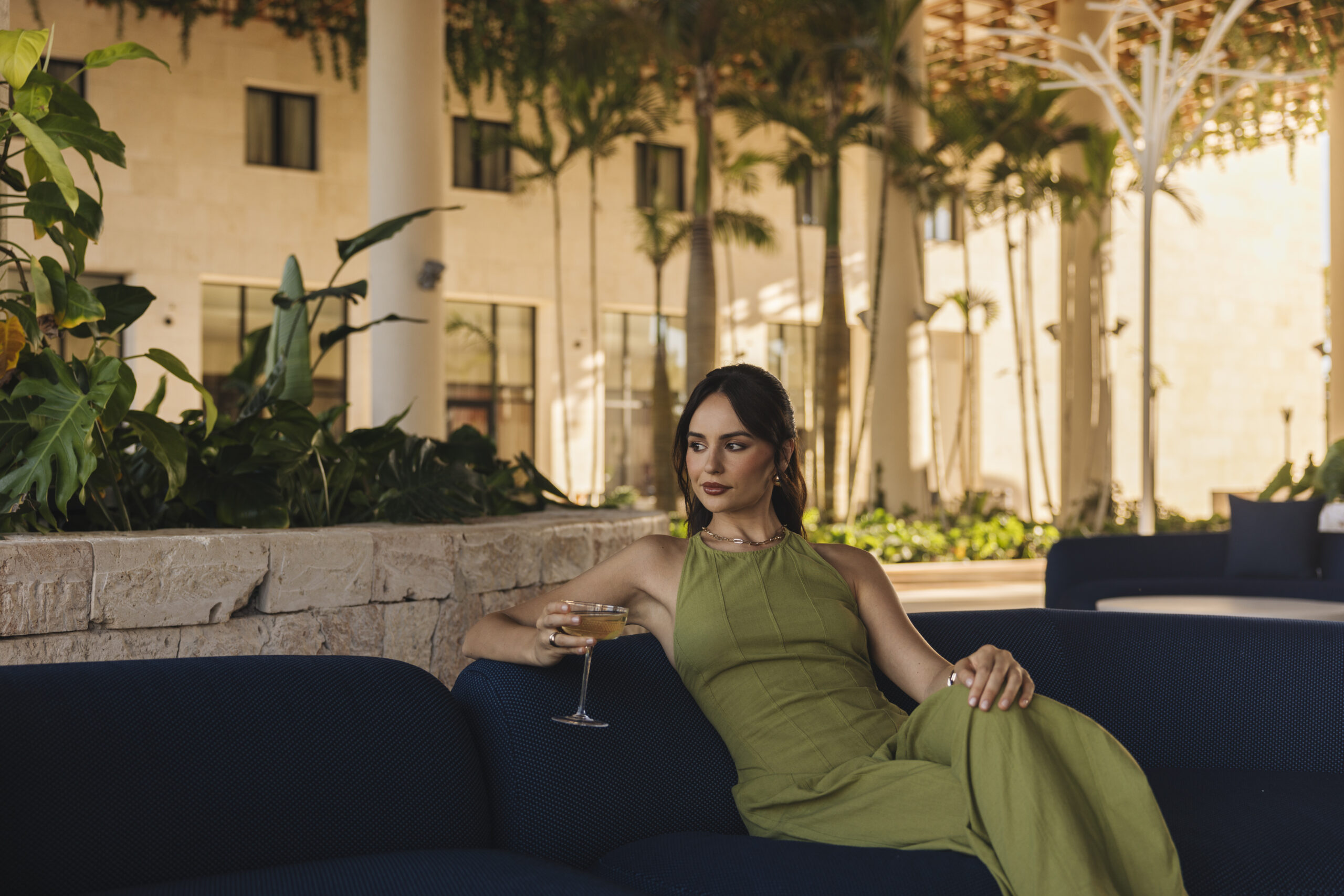 Woman in green jumpsuit at W Punta Cana resort with cocktail