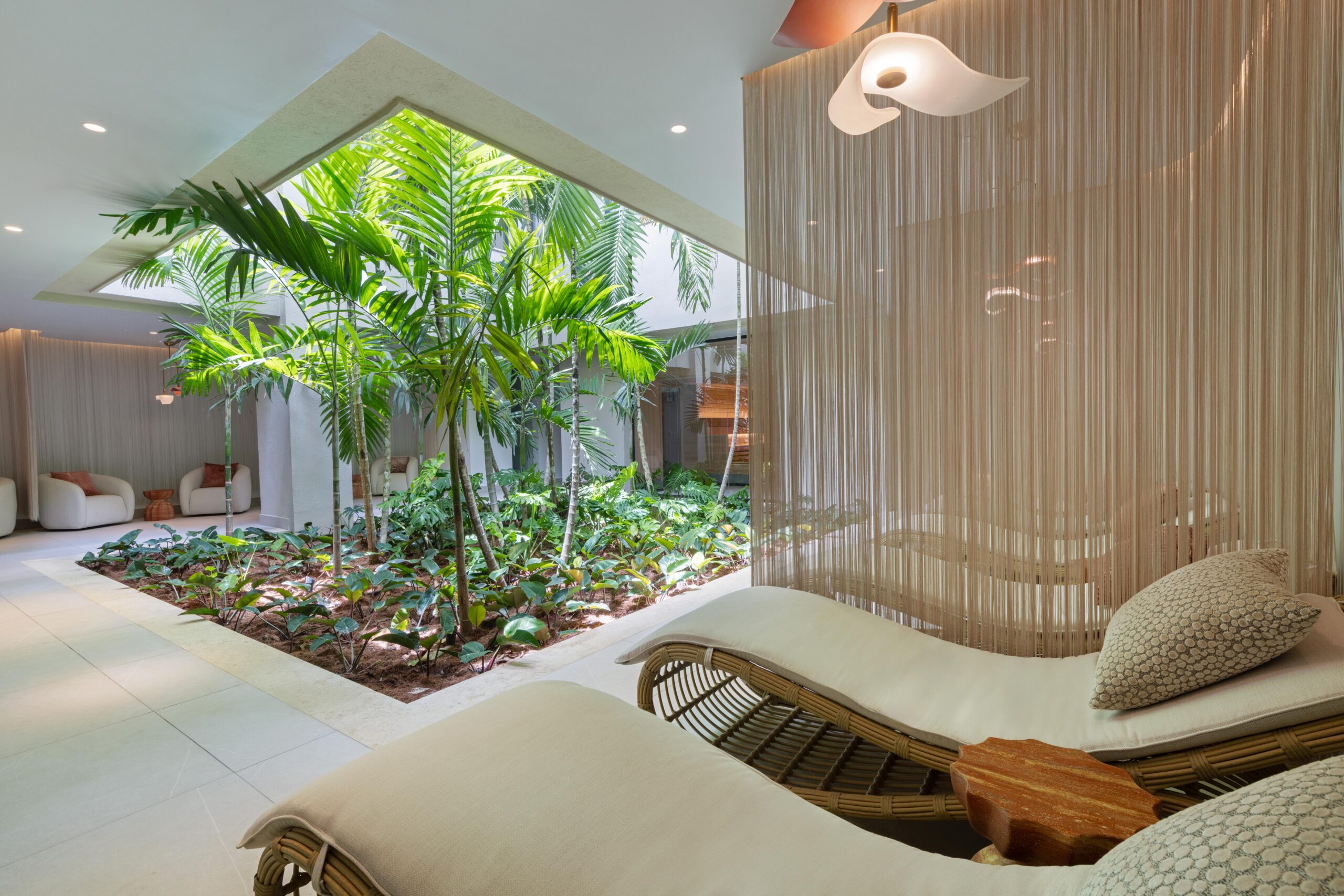 W Punta Cana adult all-inclusive resort relaxation area with lounge chairs and lush tropical garden view.