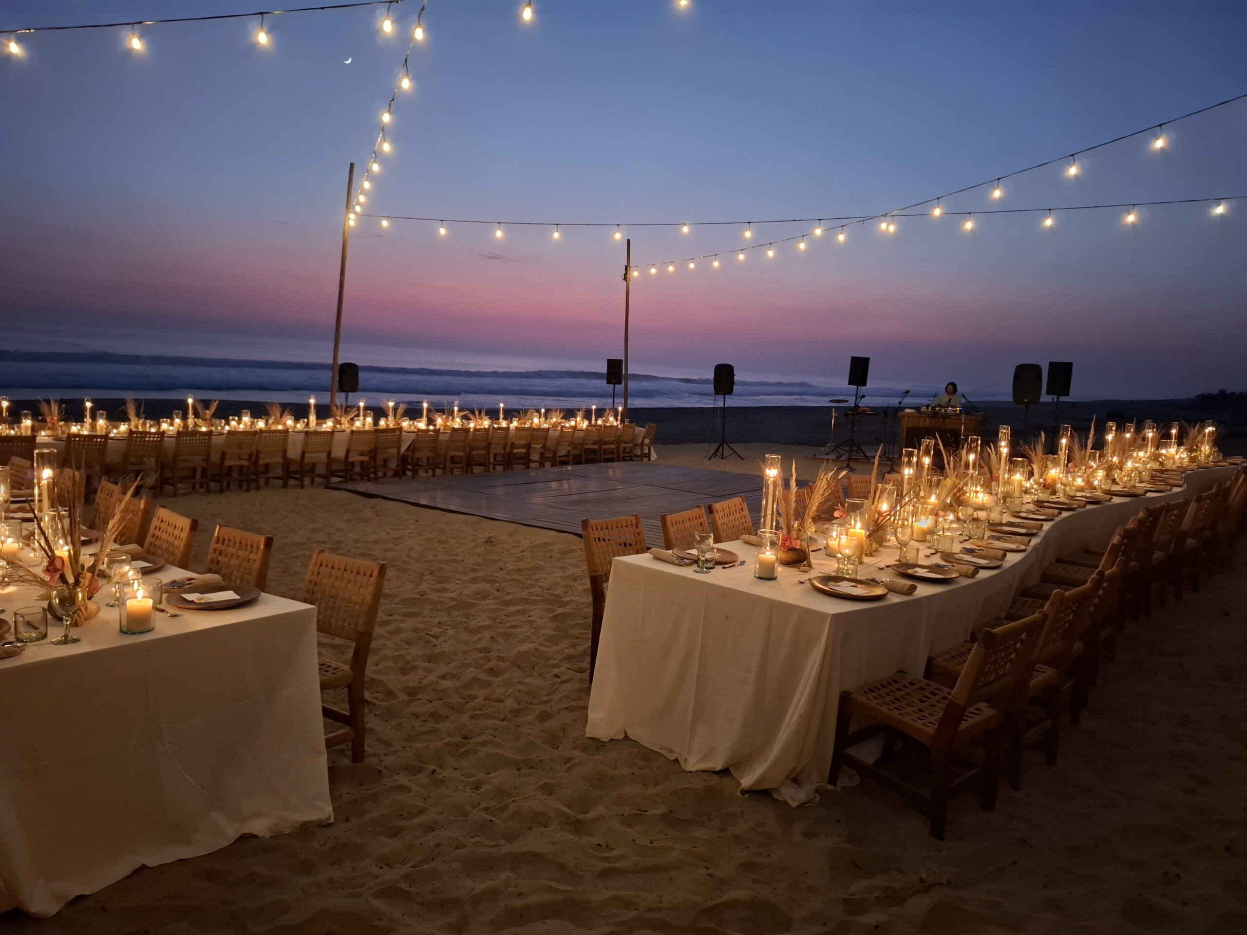 Hotel Casa Yuma beach event at sunset with long tables, candles, and string lights