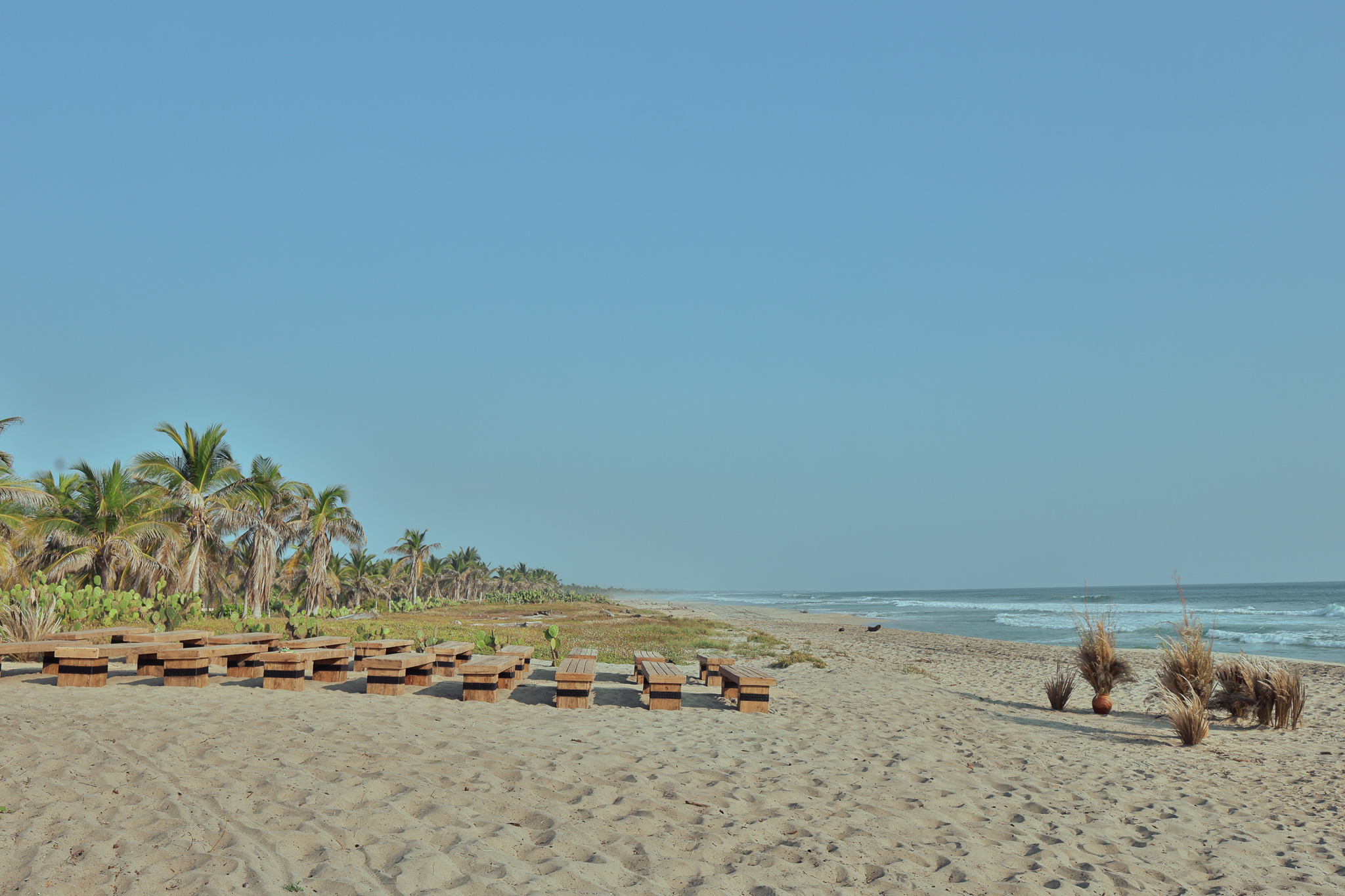 Hotel Casa Yuma: Beachside picnic tables and palm trees with ocean view