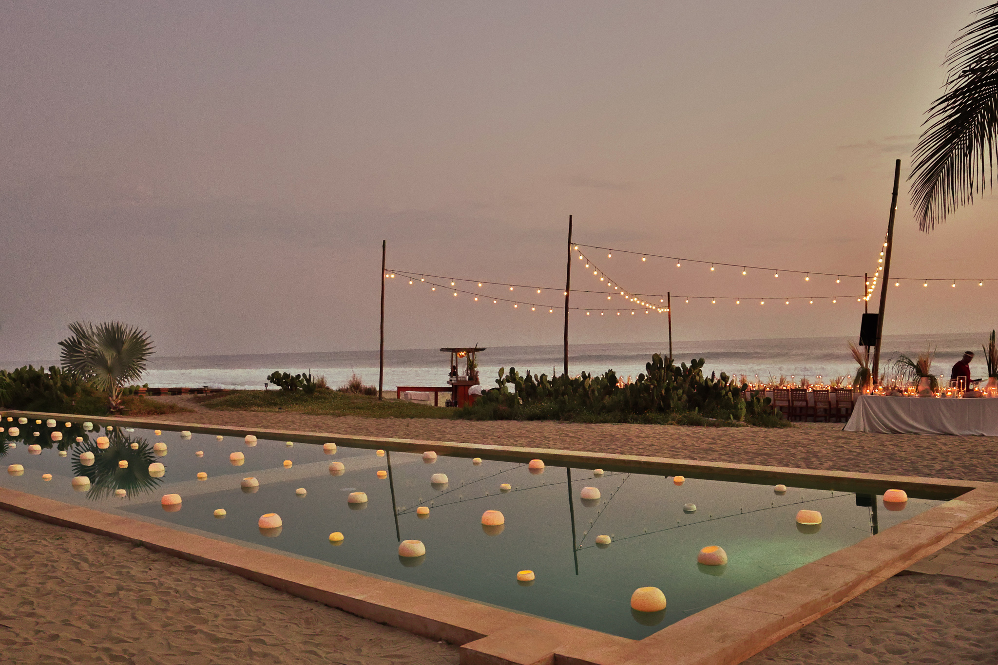 Hotel Casa Yuma: Beachfront pool with floating lights and string lights at dusk