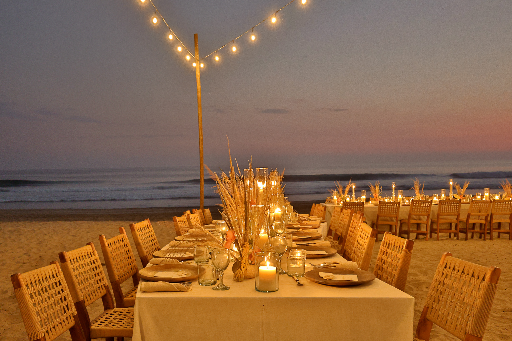 Elegant beach dinner setup at Hotel Casa Yuma with string lights and candles