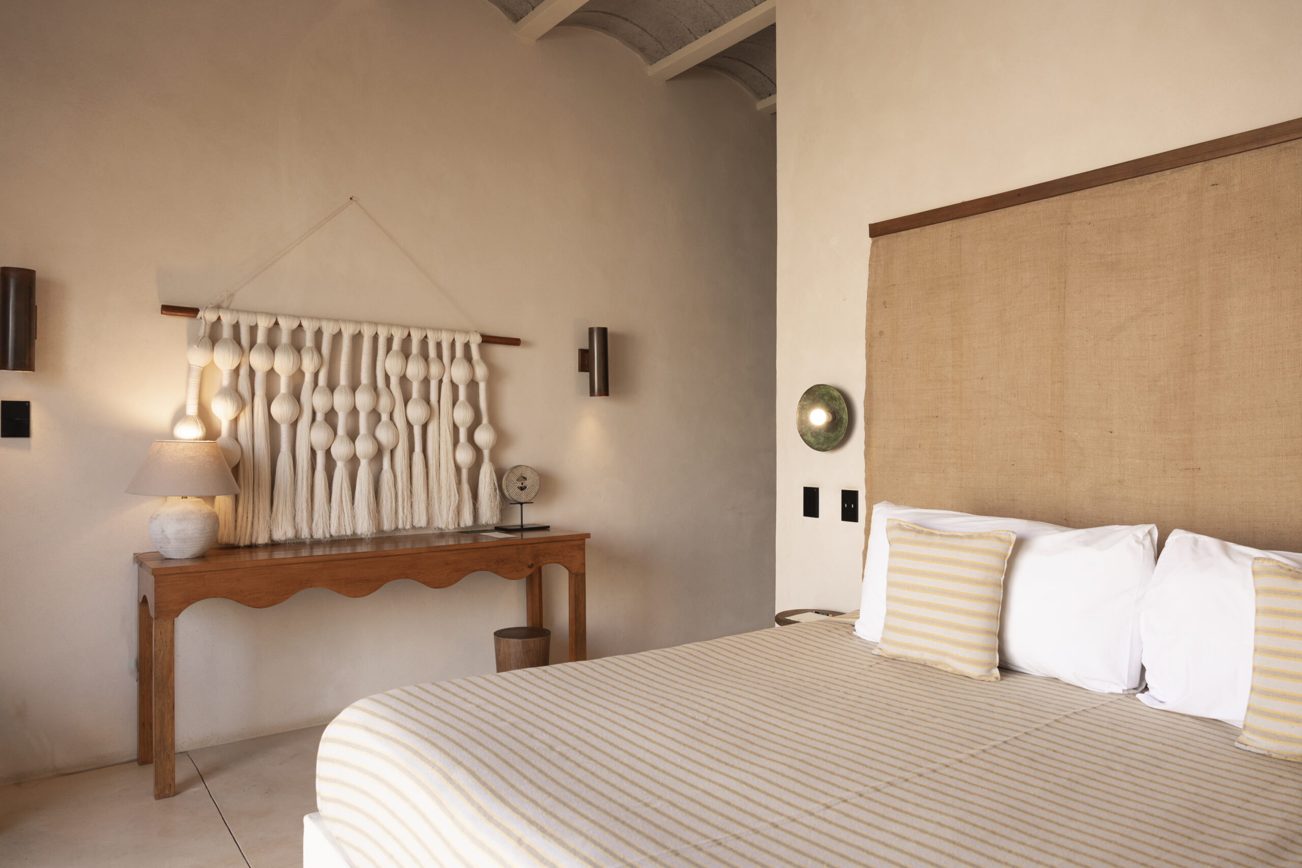 Hotel Casa Yuma bedroom with neutral tones and macrame wall hanging