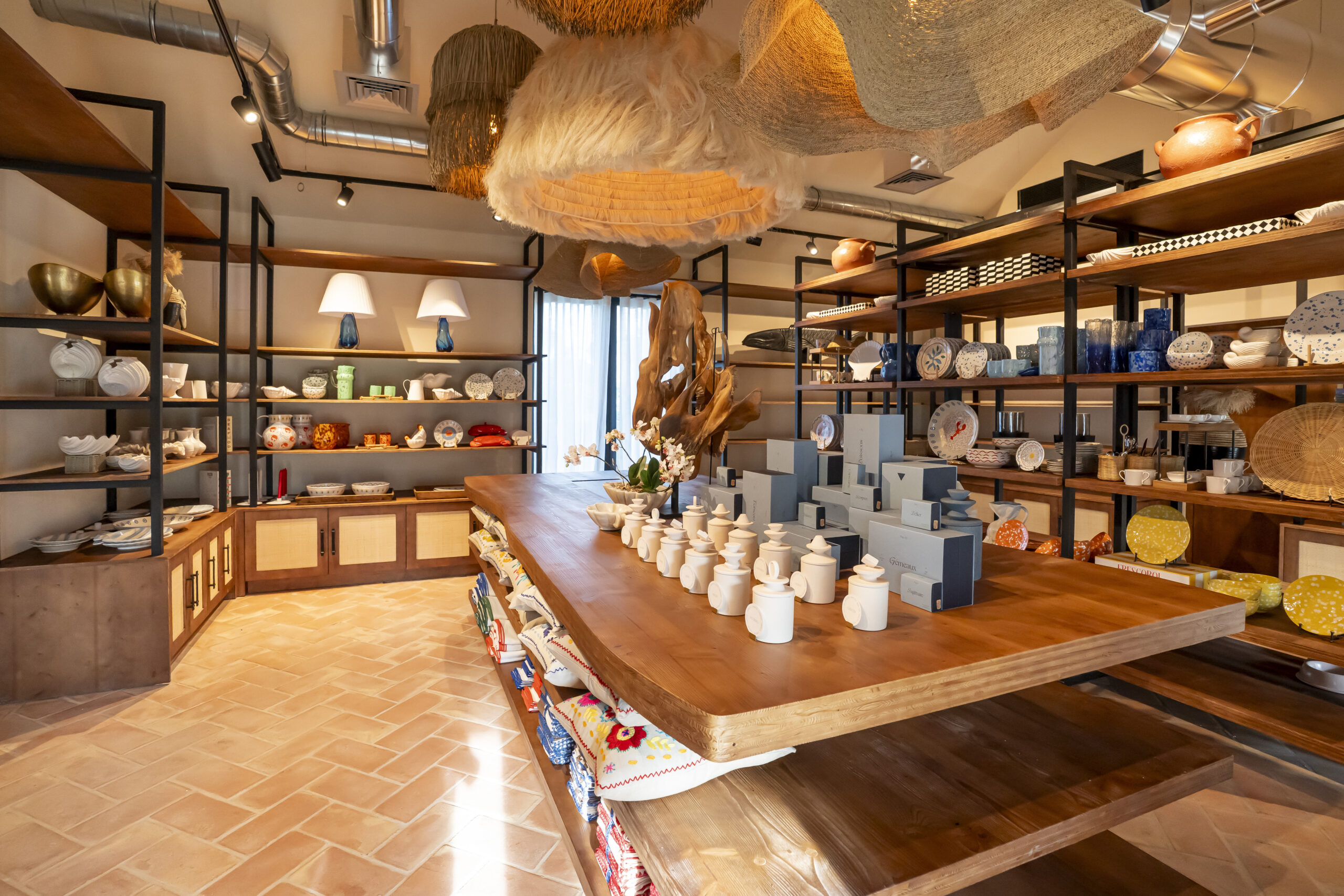 Chic boutique interior with shelves of decor and a central wooden table in Comporta