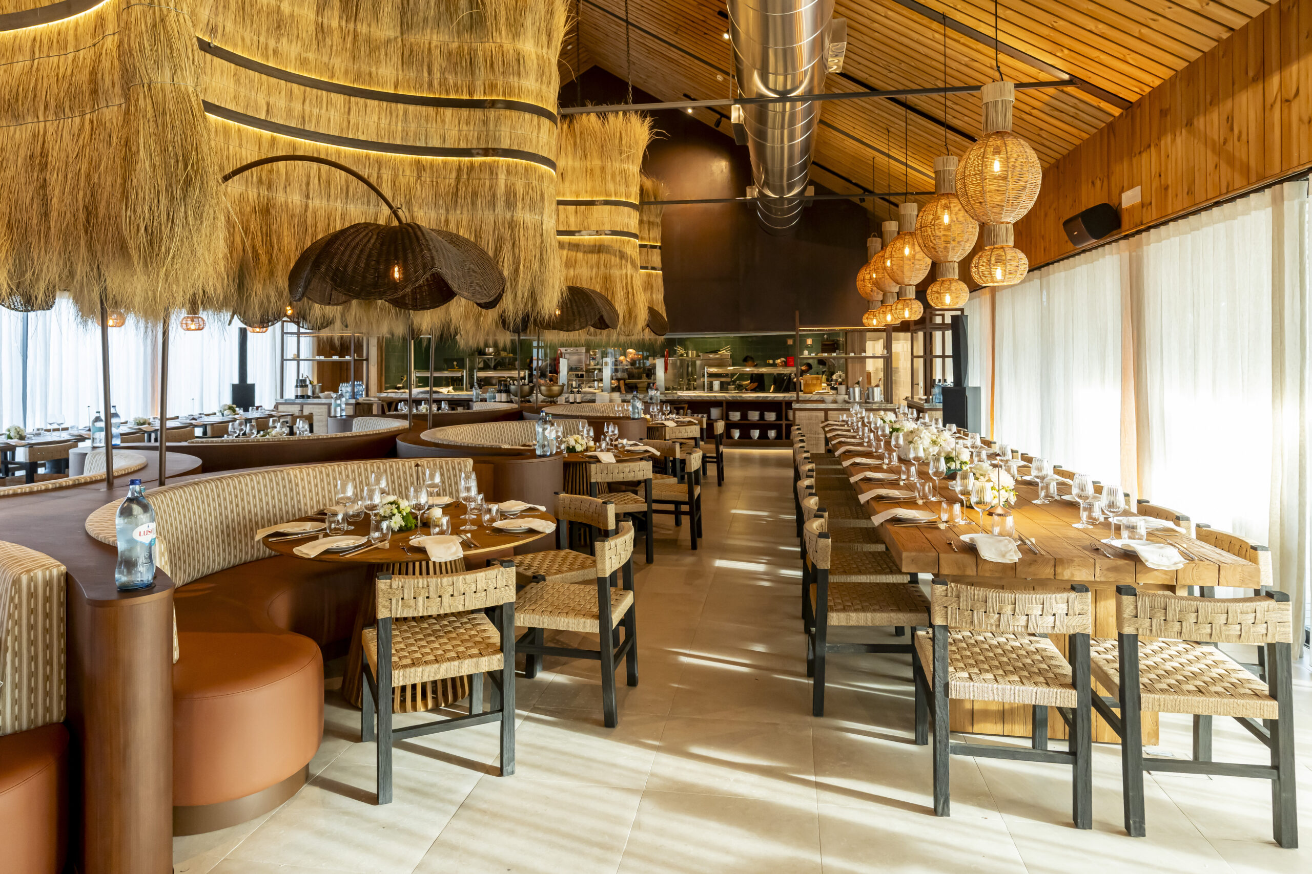 Elegant restaurant interior with thatched ceiling and wooden tables, Sublime Comporta