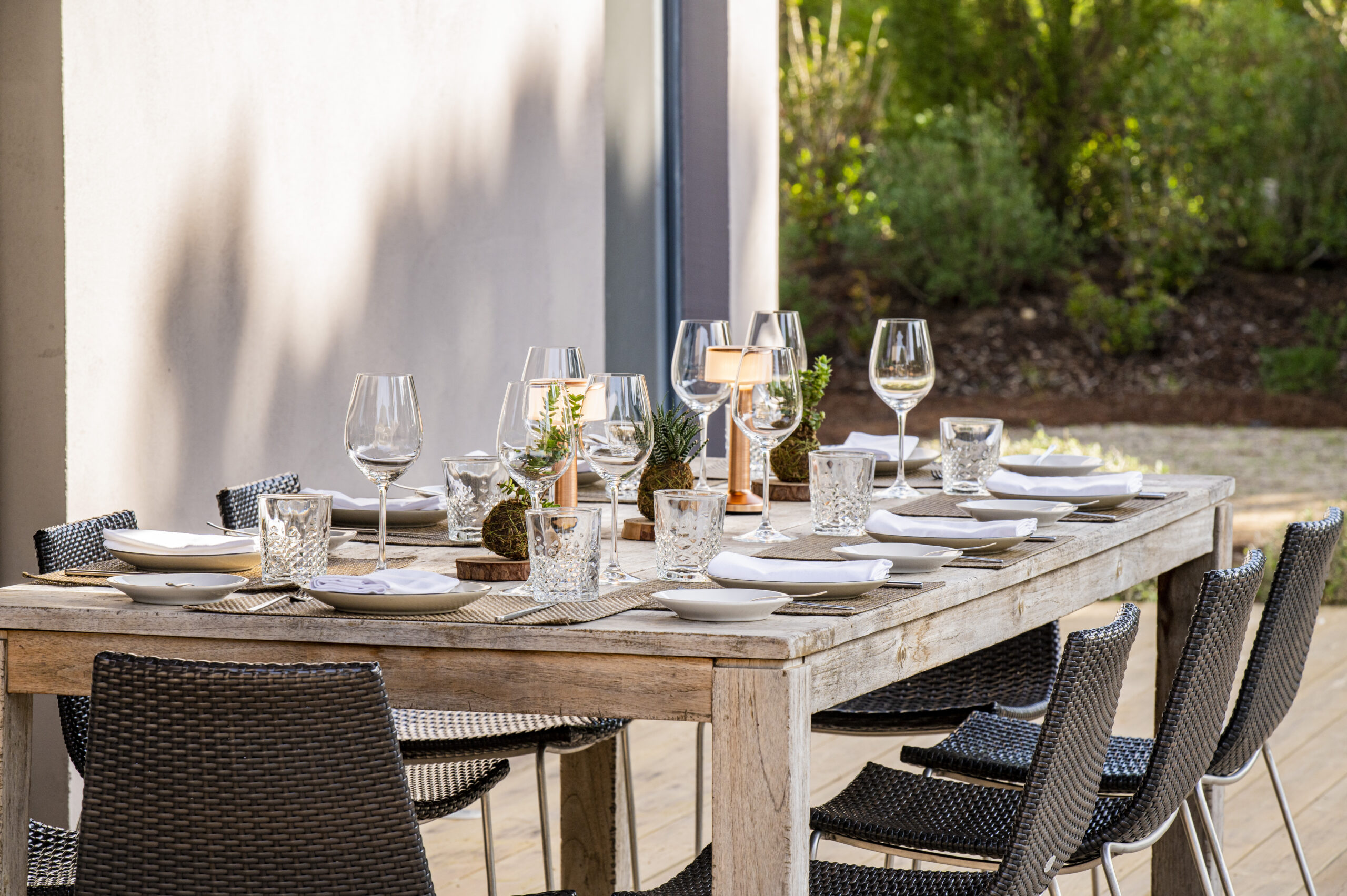 Outdoor dining table set for a meal in a garden setting, reflecting Sublime Comporta style.
