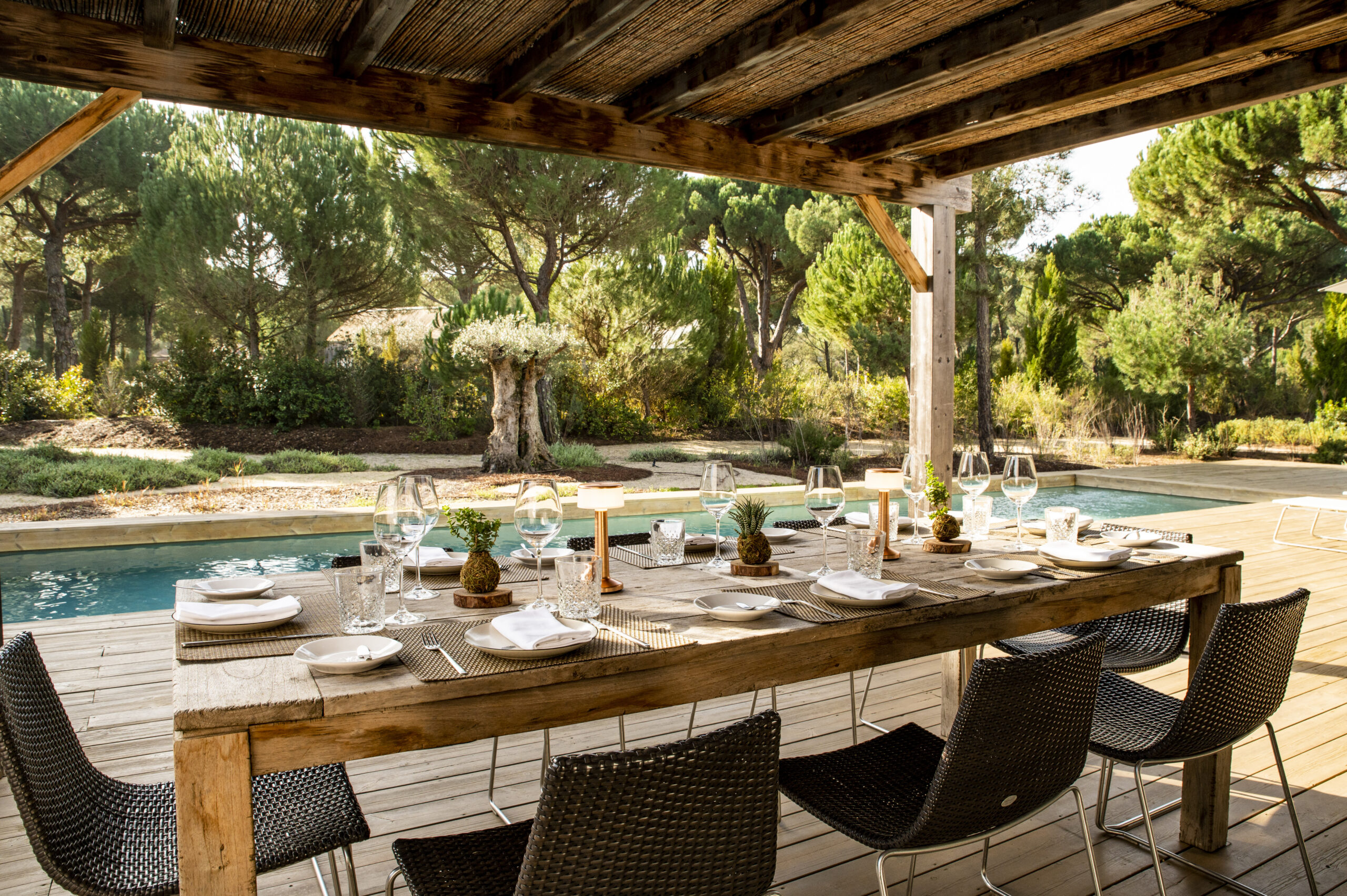 Outdoor dining table set for a meal by a swimming pool in Comporta